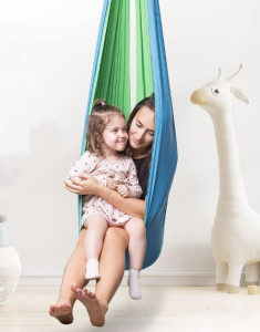 A parent and their child sitting in Sensory Harbor's Cuddle Swing for Teens and Adults.